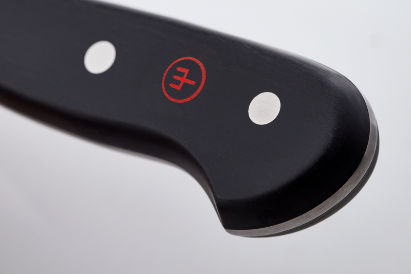 Close-up of a black knife blade with a brand logo on a light gray background