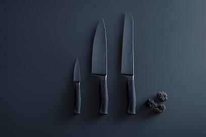 Set of three black kitchen knives on a dark gray background