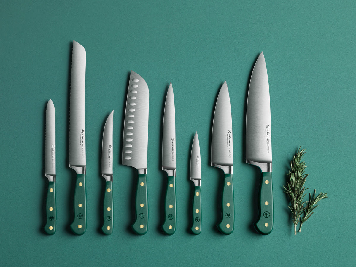 Set of knives with green handles on a teal background