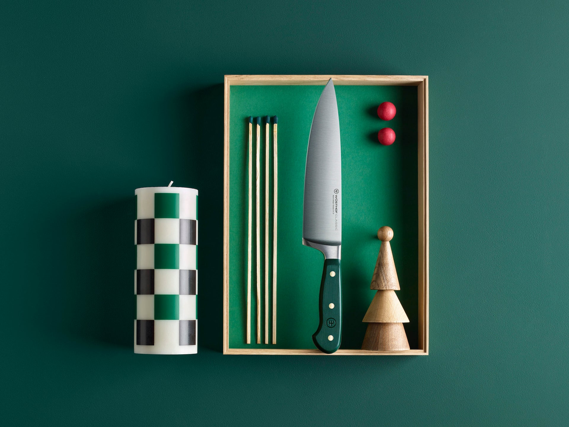 Knife with green handle in a box on a dark green background