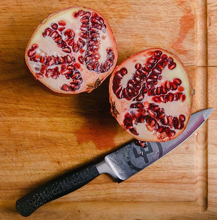 performer with a sliced pomegranate