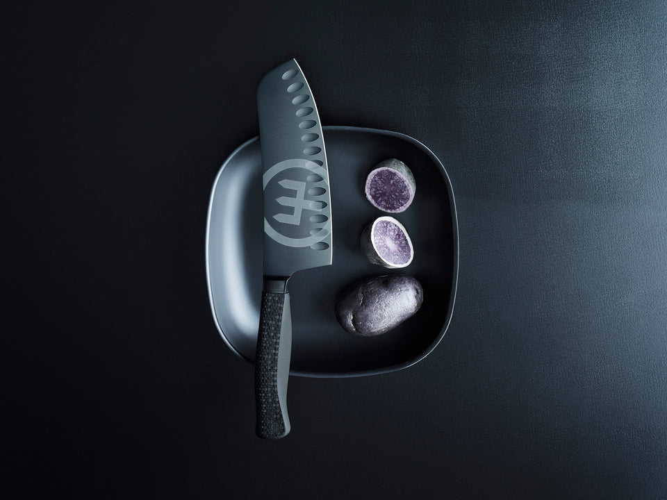 Black ceramic knife set with a decorative handle on a black background