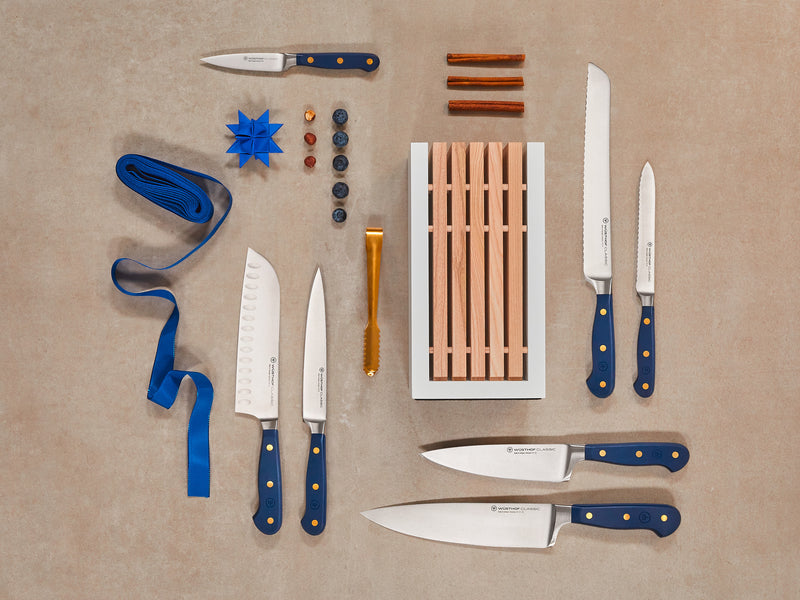 Collection of knives with blue handles on a beige background