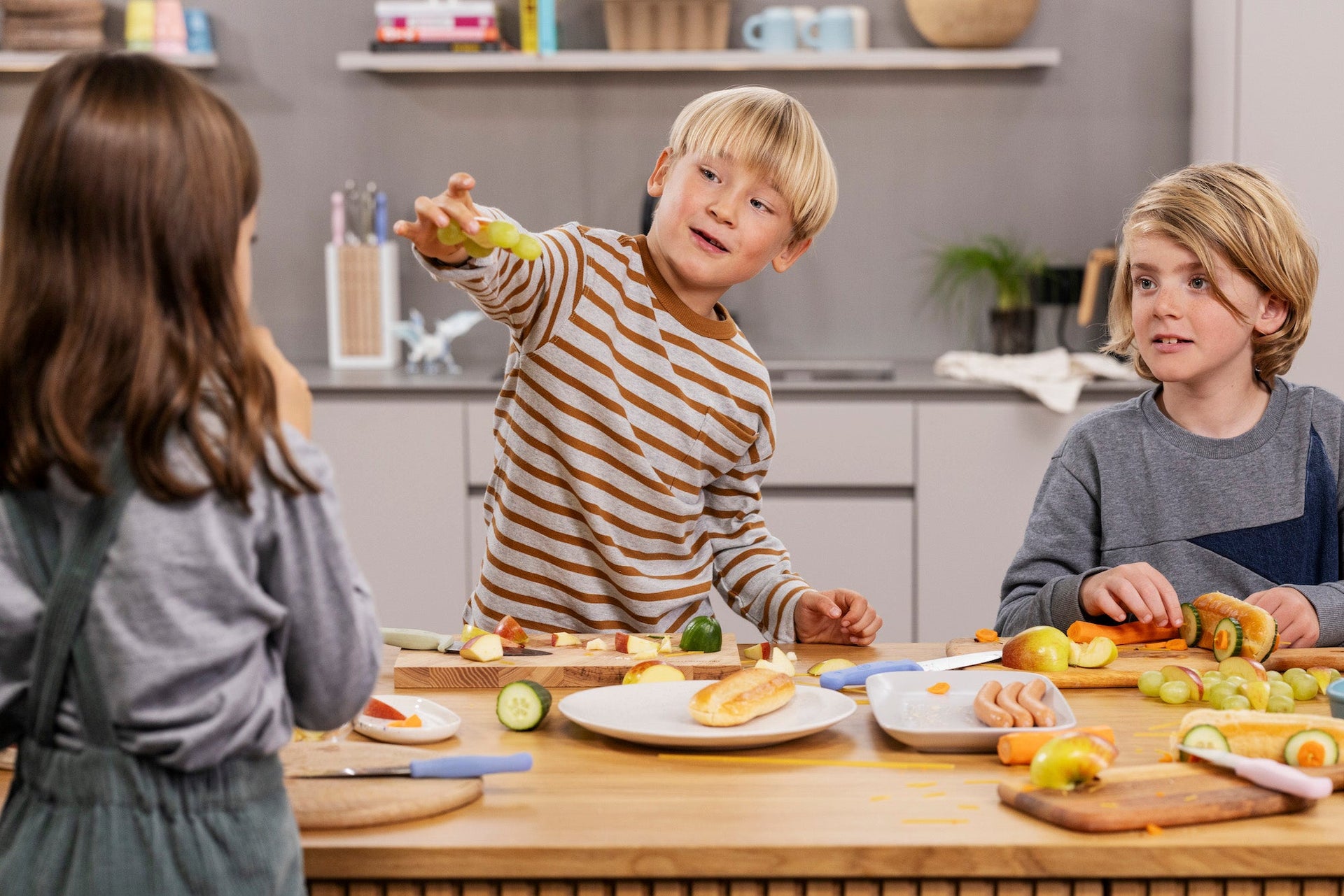 Children in a kitchen setting with food and kitchen utensils